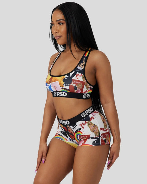 Woman wearing a two-piece swimsuit set with colorful Playboy magazine cover print and black PSD waistband.