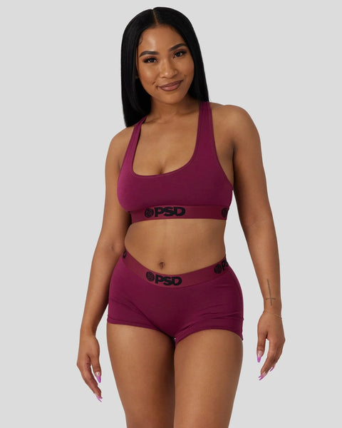 Deep burgundy modal sports bra and boy shorts set with branded waistband, displayed on model.