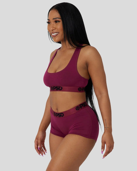 Deep burgundy racerback sports bra and boy shorts set with branded elastic waistband.
