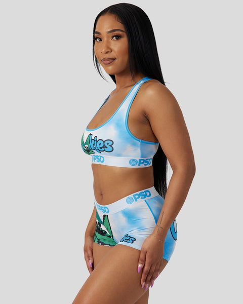 Woman wearing blue and white tie-dye sports bra and matching boy shorts with brand logos.
