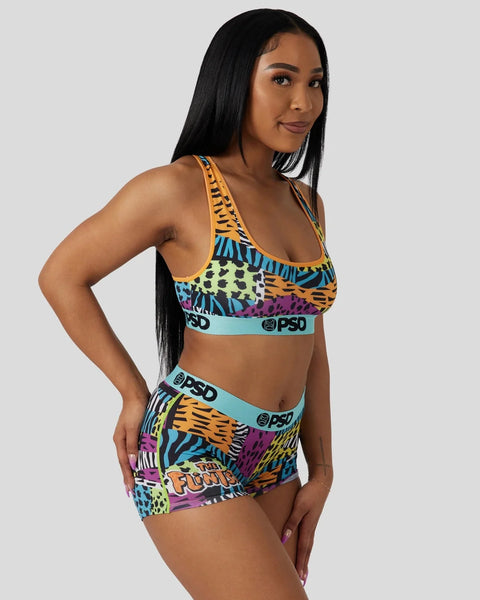 Woman wearing colorful animal print sports bra and shorts set with blue elastic bands and PSD branding.