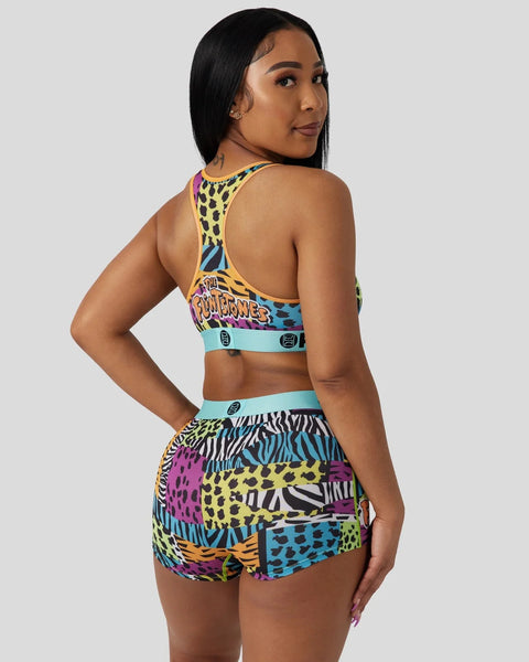 Woman wearing yellow and multicolor animal print sports bra and shorts set with 