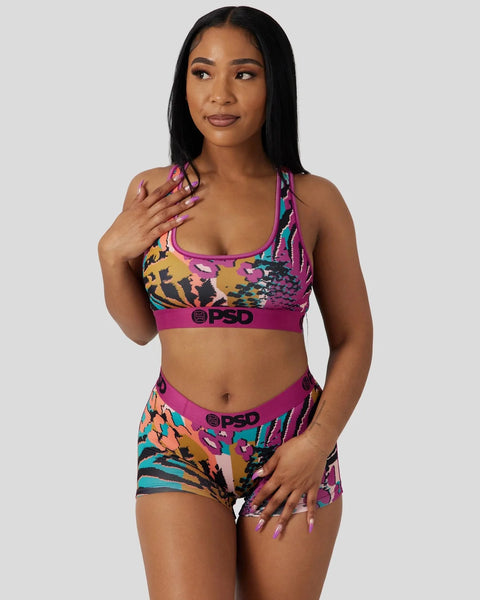 Colorful animal print sports bra and shorts set with magenta waistbands and mixed pattern design.
