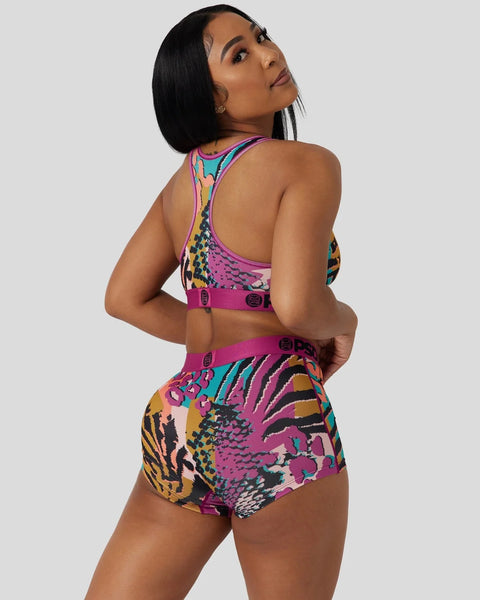 Colorful animal print sports bra and high-waisted shorts set with magenta, teal, and yellow patterns and pink straps.