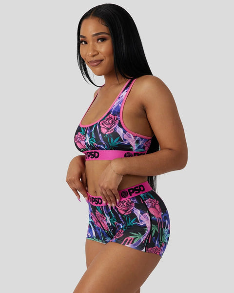 Two-piece sports set with pink and purple floral print, featuring matching sports bra and shorts with branded waistband.