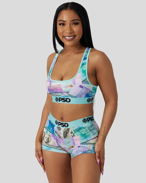 Woman wearing a two-piece set with multicolored currency print and PSD brand waistbands.