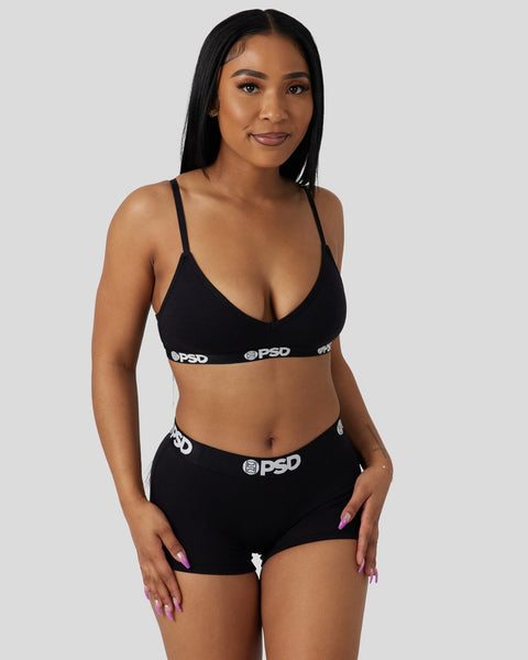 Woman wearing black modal bra and shorts set with PSD waistband branding.