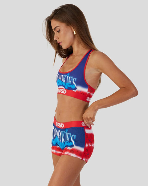 Woman wearing red and blue tie-dye sports bra and matching shorts with text graphics.