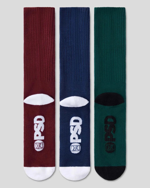 Three crew socks in burgundy, navy, and forest green with white and black logo designs and contrasting toe and heel sections.