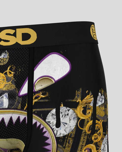 Black boxers with gold and purple graphic design featuring stylized character face with open mouth and diamond details.