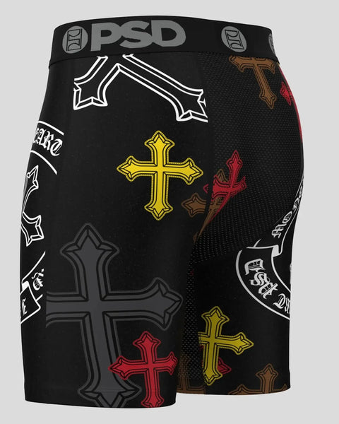Black PSD shorts with multiple decorative cross designs in white, yellow, red, and brown.