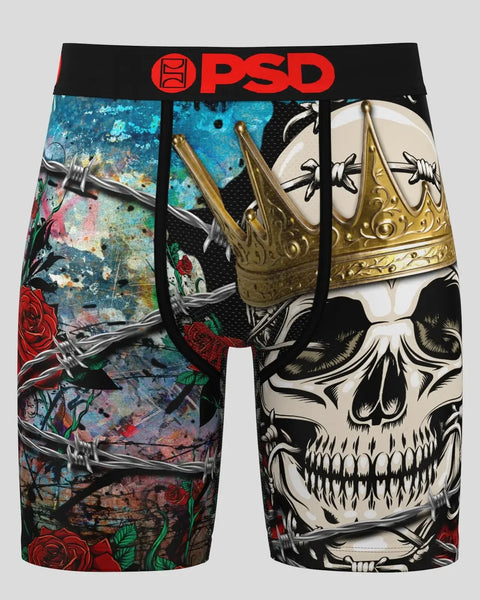 PSD boxer briefs featuring skull wearing gold crown, roses, and ornate dagger designs on multicolor background.