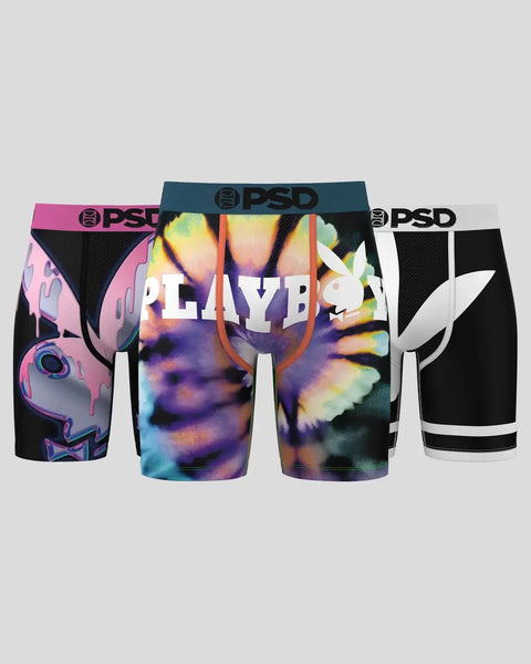 Three PSD boxer briefs with colored waistbands: pink with abstract design, multicolor tie-dye center, and black with white ac