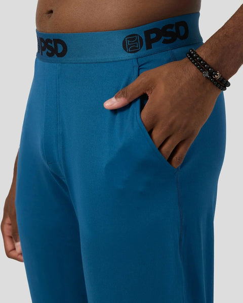 Teal lounge pants with PSD branding on waistband, shown on model with hand in front pocket.