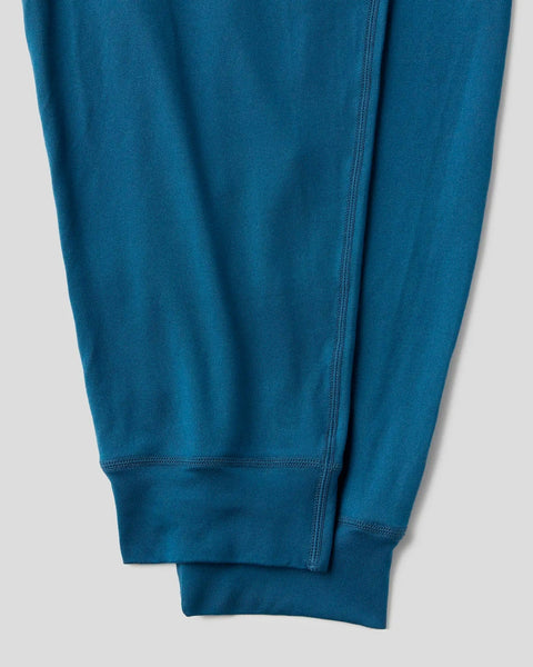 Teal lounge pant with flat-lock seams and ribbed cuffs, shown from the leg detail.