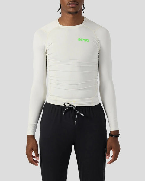Ash-colored long sleeve compression tee with green logo on chest, fitted ribbed construction.