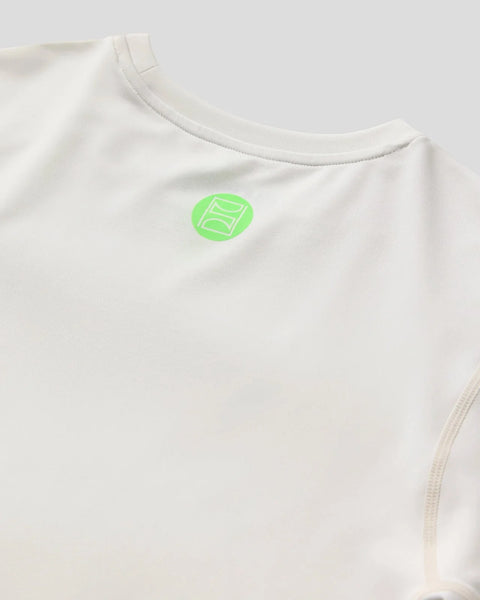 Cream long sleeve compression tee with neon green logo on chest.