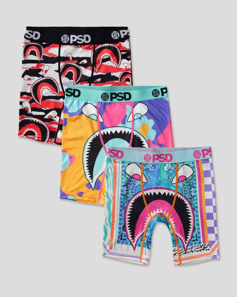 Three PSD boxer briefs with shark mouth graphic designs in red/black, turquoise/multicolor, and blue/multicolor colorways.