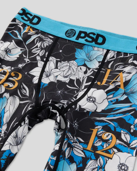 PSD brand underwear with blue waistband, black and white floral pattern, and gold numbers on leg.