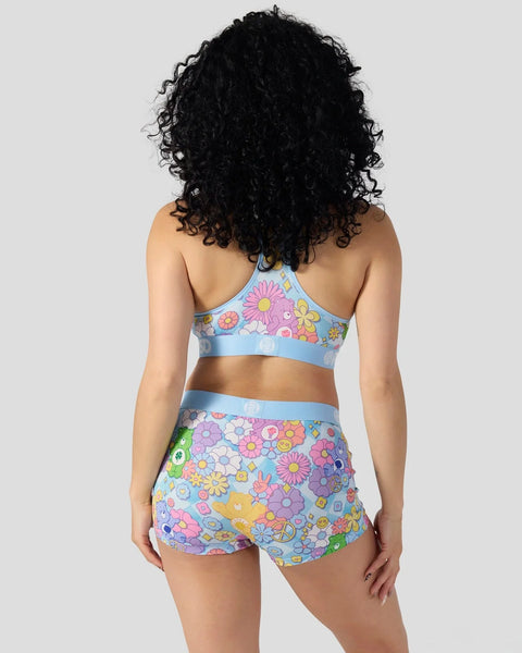Light blue two-piece swimsuit with colorful flower and Care Bears print throughout, shown from back view.