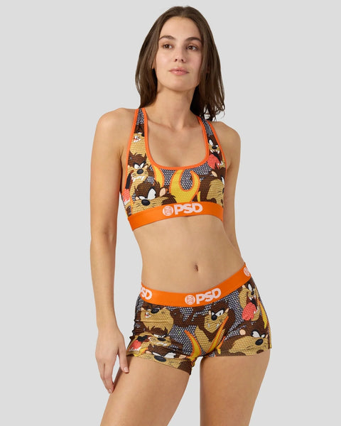 Woman wearing Looney Tunes Taz-patterned sports bra and shorts with orange PSD waistbands.