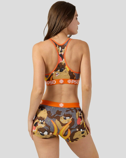 Woman wearing Looney Tunes Taz graphic sports bra and shorts set with orange trim and PSD waistband.