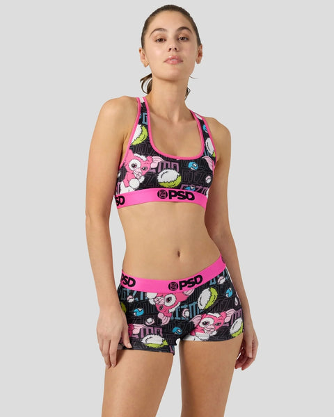 Woman wearing black and neon pink sports bra and shorts set with Gizmo character print and PSD waistband.