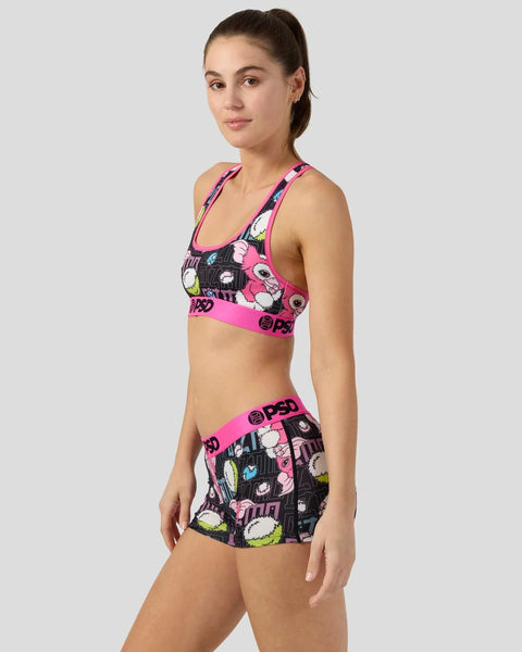 Woman wearing neon pink and black sports bra and shorts set with Gizmo character print and PSD branding.