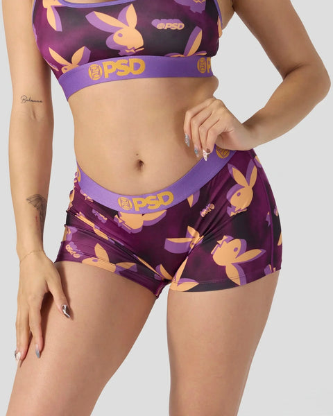 Purple and gold Playboy bunny print sports bra and shorts set with PSD branding on elastic waistbands.