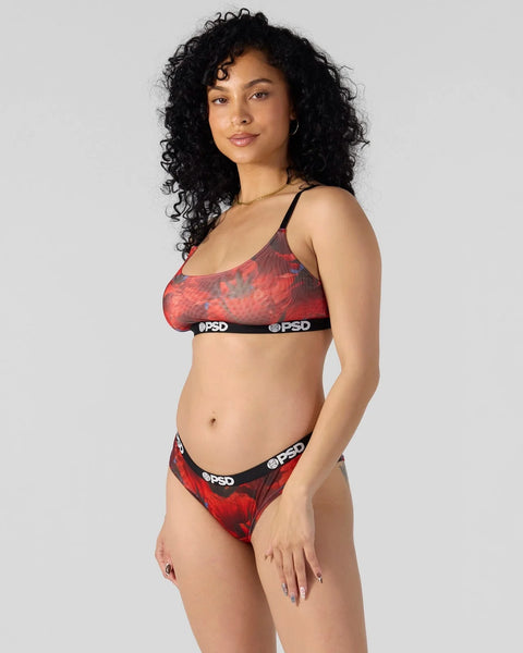 Woman wearing red and black patterned bra and briefs with branded elastic waistband.