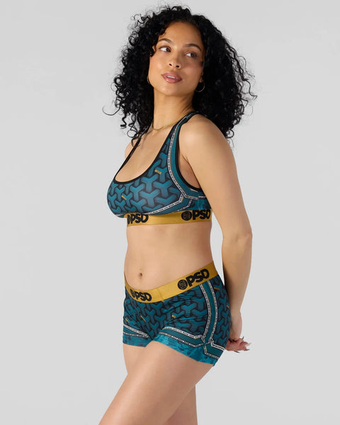 Teal patterned sports bra and shorts set with yellow and black branded waistband and decorative stitching details.