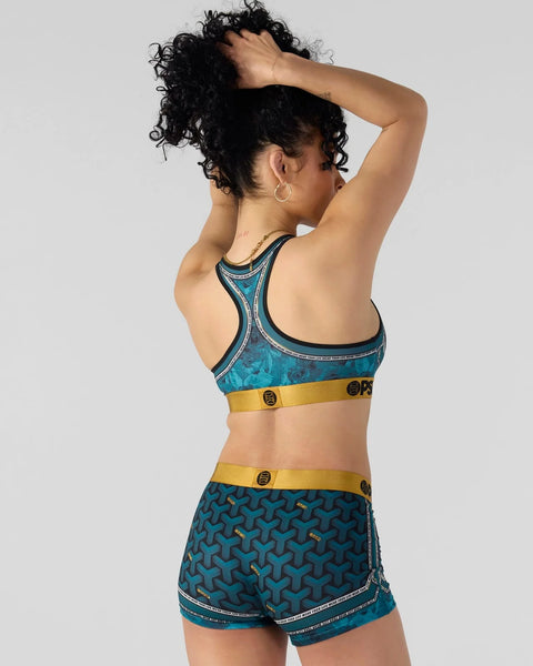 Teal sports bra and matching shorts with geometric pattern and gold accent bands, shown from back view.