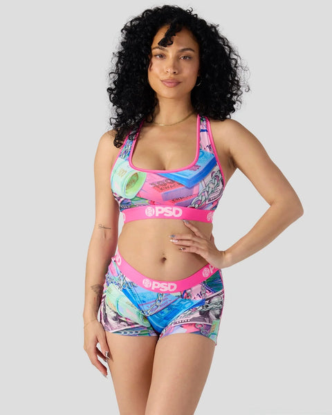 Woman wearing pink and blue patterned sports bra and matching shorts with PSD branding.