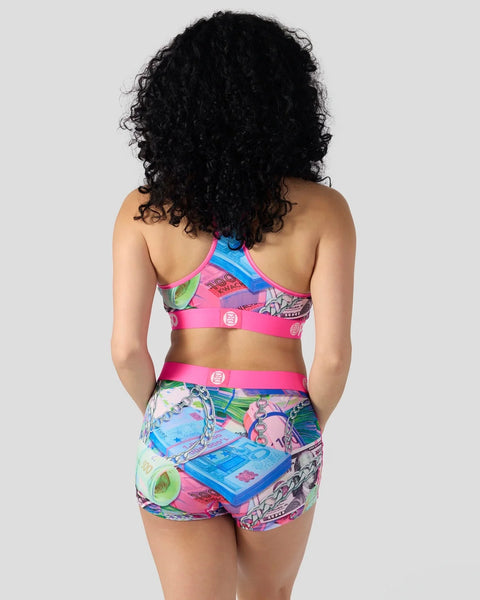 Woman wearing colorful World Stackz two-piece set with pink and blue neon printed pattern and matching sports bra top, back v
