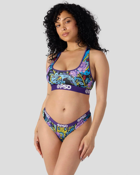 Two-piece swimsuit with purple paisley and floral pattern, matching sports bra top and bikini bottom with brand waistband.