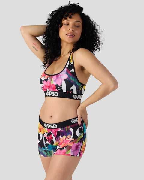 Black sports bra and shorts set with pink, yellow, and teal floral print and PSD branding.