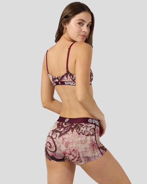 Woman wearing burgundy jacquard patterned bra and shorts set with decorative floral and geometric designs.