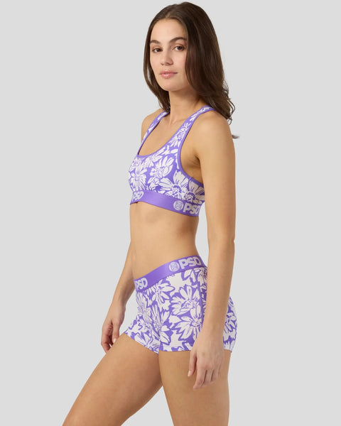 Purple and white floral sports bra and shorts set with branded waistband on model.