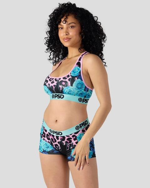Sports bra and shorts set with leopard print, blue roses, and turquoise waistband with branding.