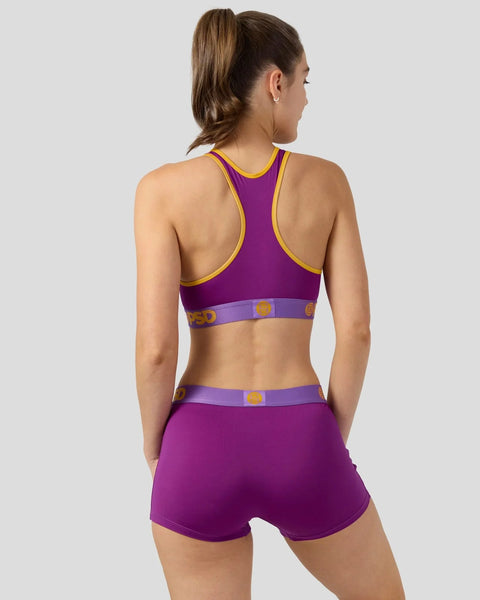 Purple sports bra and shorts set with yellow trim and branded waistband, shown from back view.