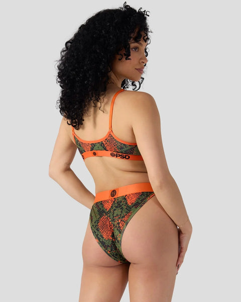 Woman wearing orange and green snake-print two-piece underwear set with matching choker necklace, shown from behind.
