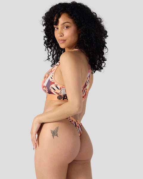 Woman wearing two-piece swimsuit with abstract coral and dark patterned design.