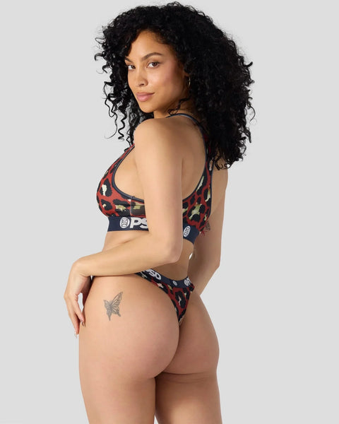 Woman wearing red and black leopard print sports bra and matching thong with brand waistband.