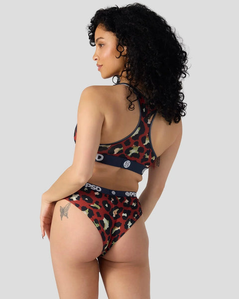 Woman wearing dark red leopard print sports bra and matching briefs with navy waistband.