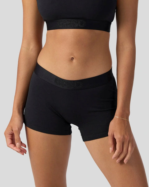 Black modal sports bra and shorts set with shimmer waistbands on model.