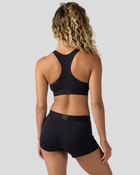 Black racerback sports bra and shorts set shown from back view on model.