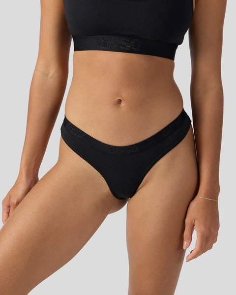 Black modal crop top and bikini briefs with shimmer waistband on model.