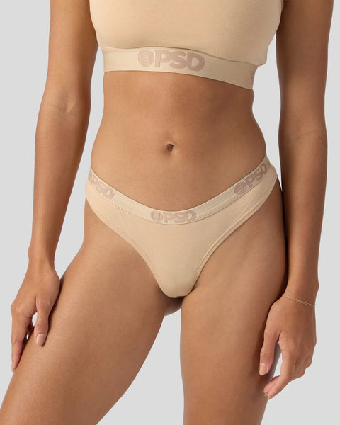 Beige modal sports bra and thong underwear set with branded elastic waistband.