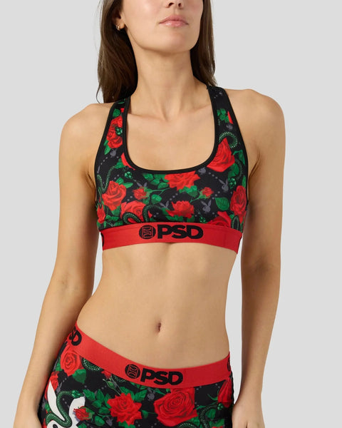 Black sports bra with red roses and green leaves, red waistband with PSD logo, matching briefs visible below.