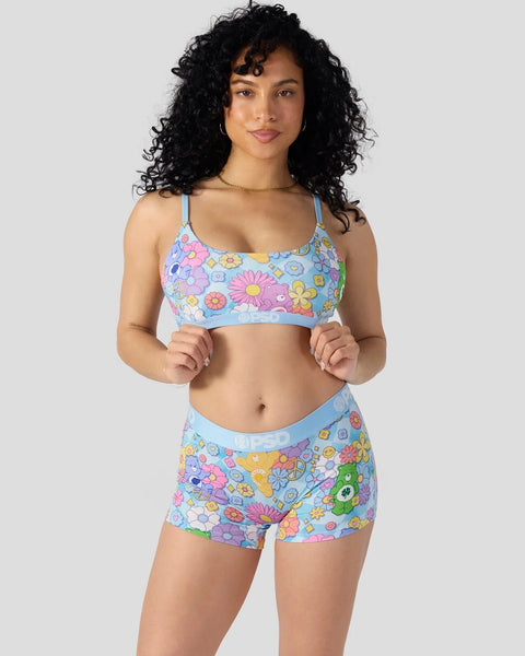 Two-piece swimsuit with multicolored flower and smiley face print on light blue background, featuring spaghetti straps and ma